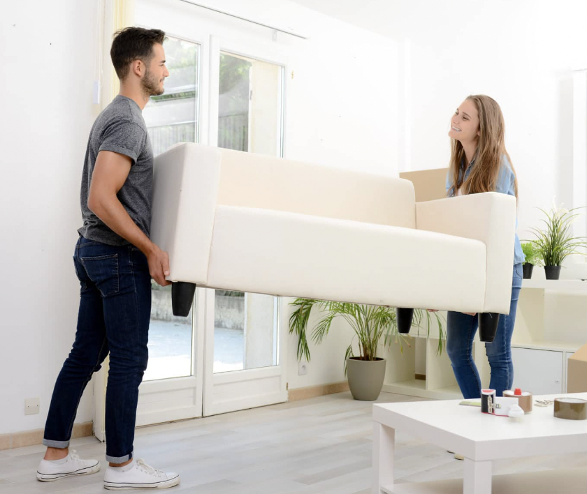 Two people lifting a couch