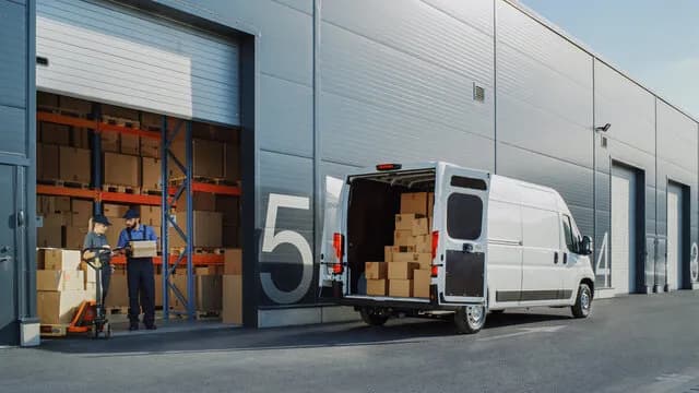 Two people moving boxes